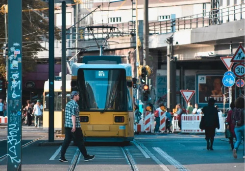 Personne qui traverse devant un tram dans une ville